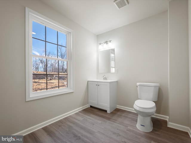 bathroom featuring toilet, hardwood / wood-style flooring, and vanity