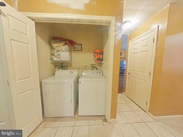 laundry room with independent washer and dryer and light tile patterned flooring