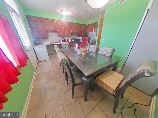 tiled dining area with washer / clothes dryer