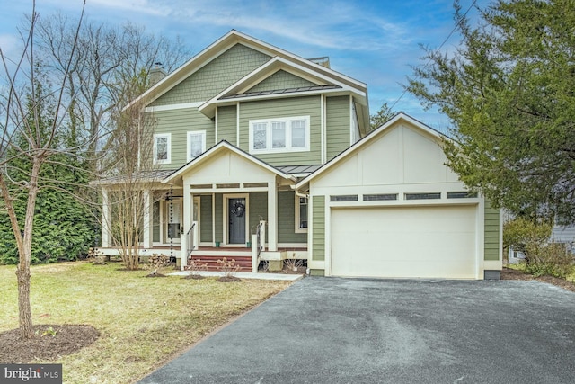 view of front of house with a porch, a garage, and a front lawn