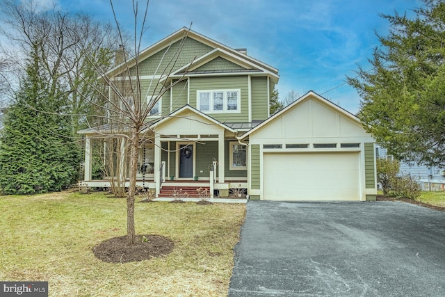 view of front facade featuring a porch, a garage, and a front yard