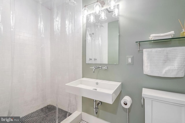 bathroom featuring toilet, sink, and a shower with curtain