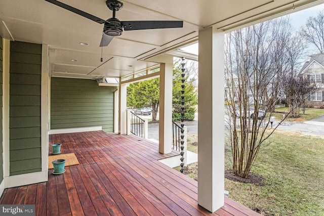 wooden deck featuring ceiling fan and a lawn