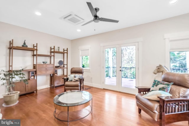 living area featuring french doors, ceiling fan, plenty of natural light, and wood-type flooring