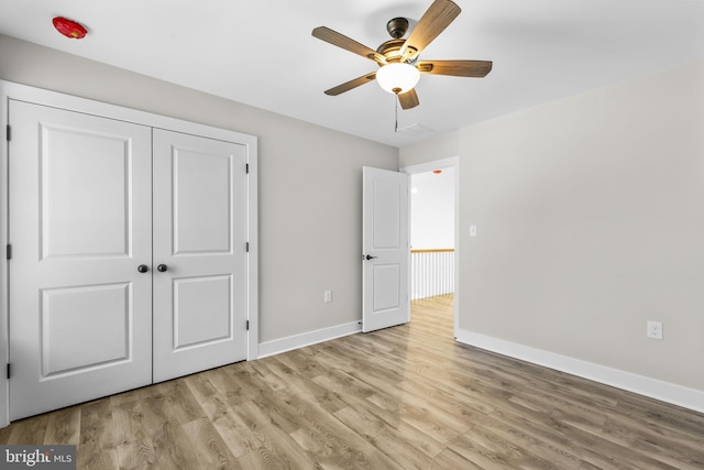 unfurnished bedroom with a closet, light hardwood / wood-style floors, and ceiling fan