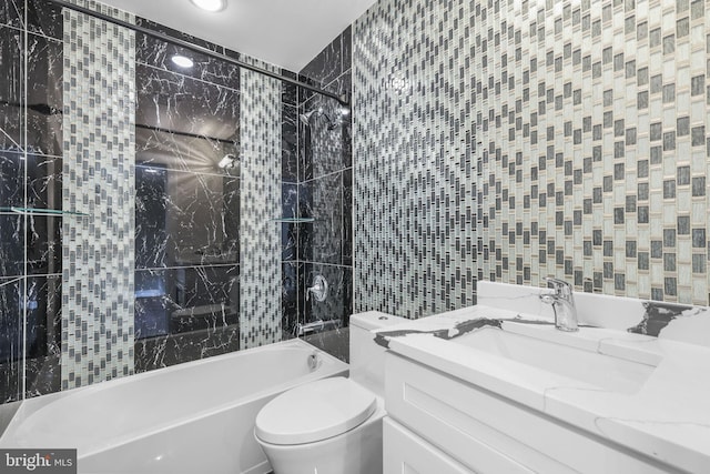 full bathroom with tile walls, toilet, vanity, and shower / tub combo with curtain