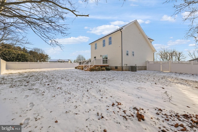 snow covered rear of property with central air condition unit