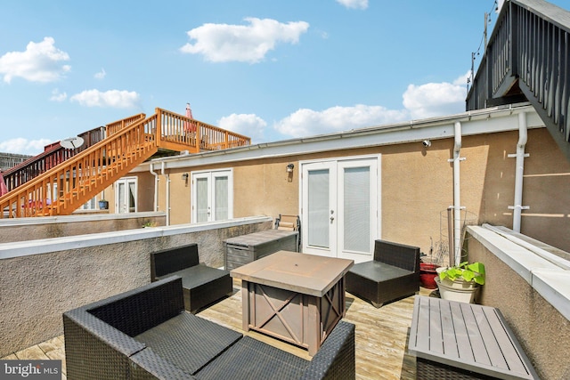 wooden deck featuring french doors and an outdoor living space with a fire pit