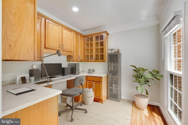 home office featuring light hardwood / wood-style flooring, ornamental molding, and built in desk