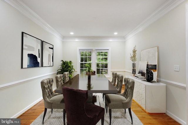 dining area with crown molding and light hardwood / wood-style floors