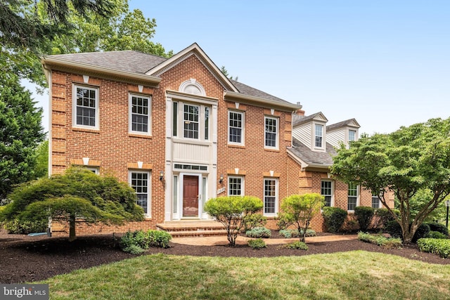 colonial home featuring a front lawn