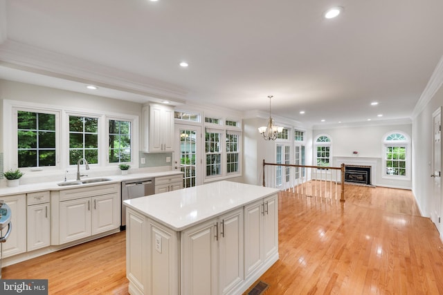 kitchen featuring white cabinetry, sink, pendant lighting, and a center island