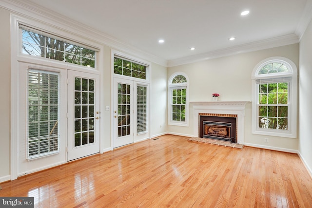 unfurnished living room featuring light hardwood / wood-style floors and crown molding