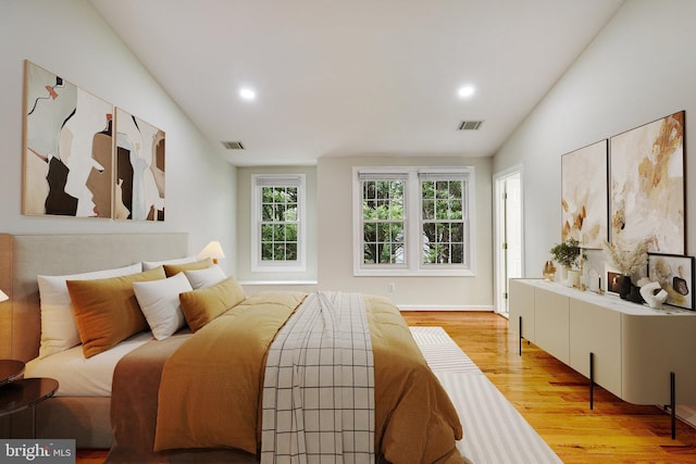 bedroom with vaulted ceiling and light hardwood / wood-style flooring