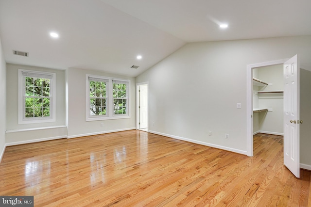 interior space with light wood-type flooring and vaulted ceiling