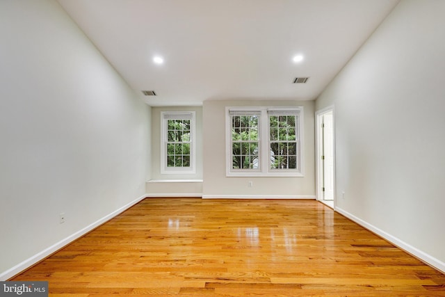 unfurnished room with lofted ceiling and light hardwood / wood-style floors