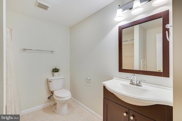 bathroom featuring toilet, vanity, and tile patterned flooring