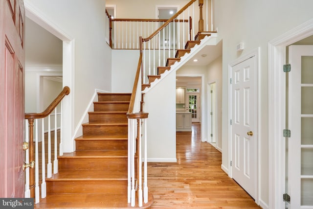 stairway featuring wood-type flooring and crown molding