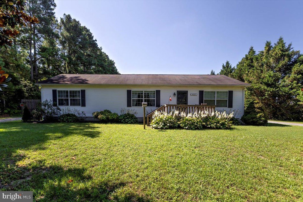 ranch-style house with a front yard and a wooden deck