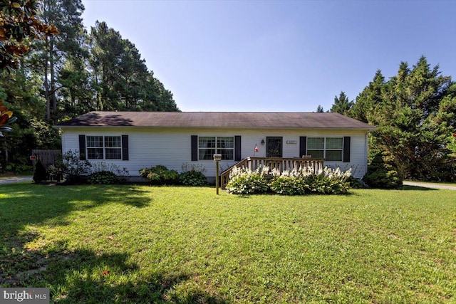 ranch-style house with a front yard and a wooden deck