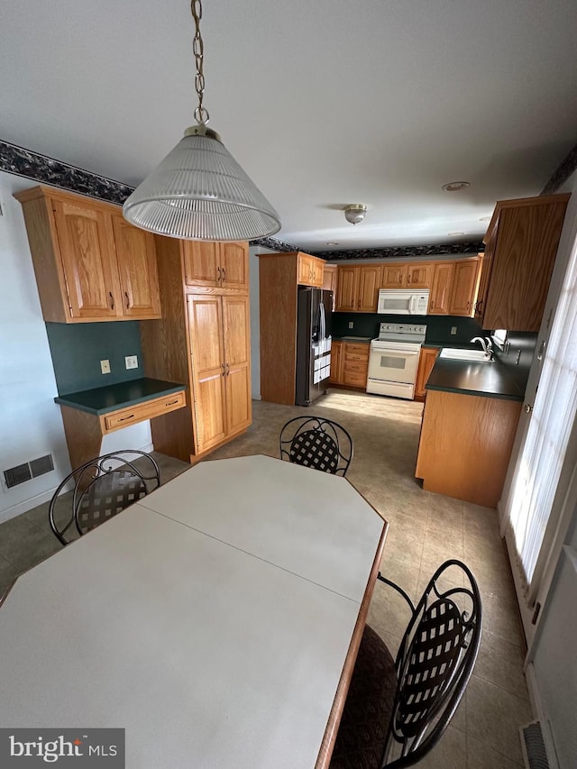 kitchen featuring light tile patterned flooring, white appliances, sink, and hanging light fixtures