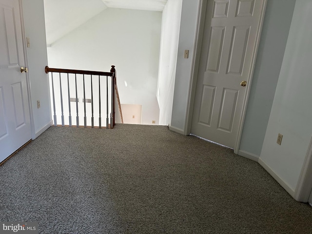 carpeted empty room with lofted ceiling