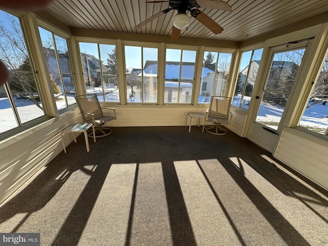 unfurnished sunroom featuring a water view and ceiling fan