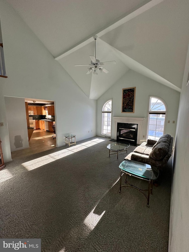 living room with a wealth of natural light, high vaulted ceiling, and carpet flooring