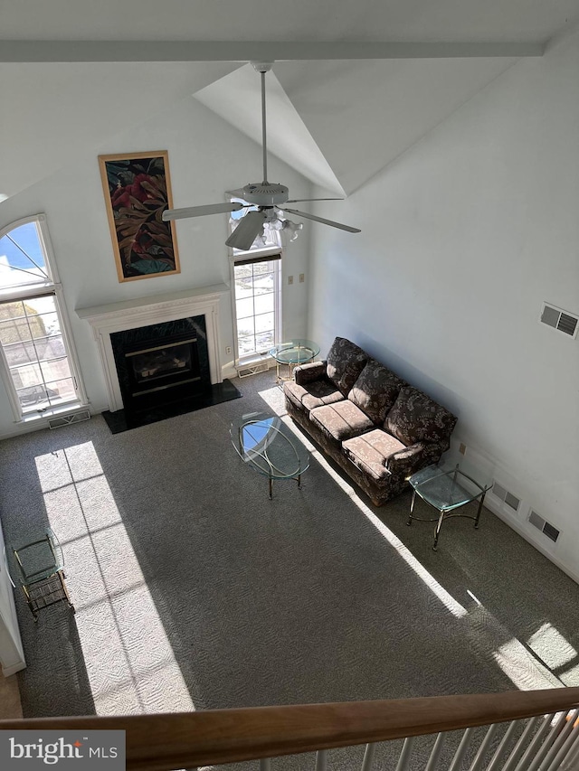 unfurnished living room featuring ceiling fan, high vaulted ceiling, a fireplace, and carpet floors