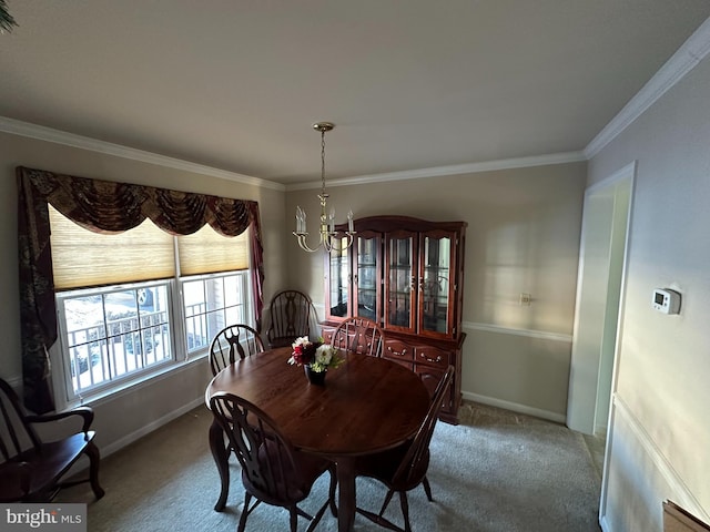 dining area with ornamental molding, carpet, and a notable chandelier