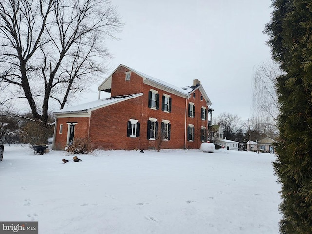 view of snow covered back of property