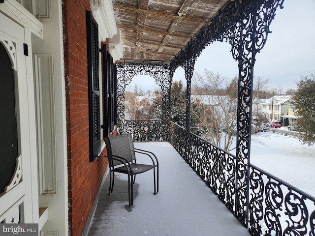 view of snow covered back of property