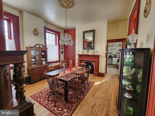 dining area featuring light hardwood / wood-style flooring and a notable chandelier