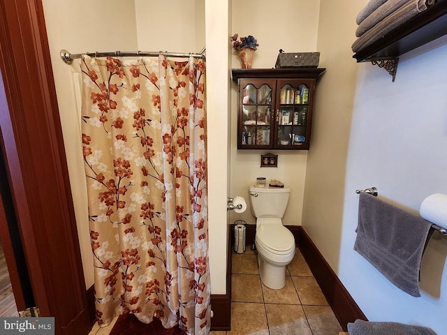 bathroom featuring a shower with curtain, toilet, and tile patterned floors