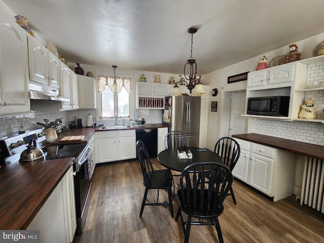 kitchen featuring decorative light fixtures, black appliances, and butcher block counters