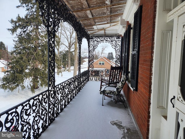 view of snow covered back of property