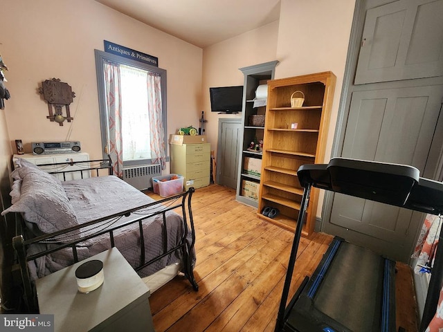 bedroom with light wood-type flooring and radiator heating unit