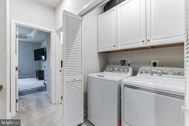 laundry area featuring cabinets, separate washer and dryer, and light carpet