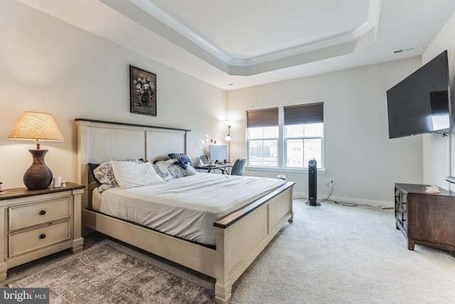 carpeted bedroom featuring ornamental molding and a raised ceiling