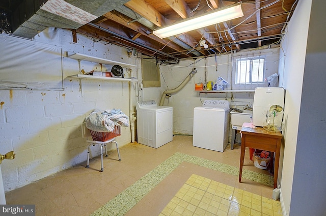 clothes washing area with washer and clothes dryer and sink