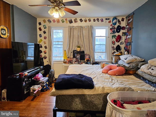 bedroom with multiple windows, hardwood / wood-style flooring, and ceiling fan