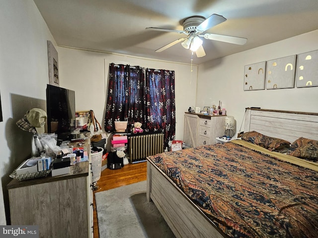 bedroom featuring ceiling fan, radiator, and light hardwood / wood-style floors