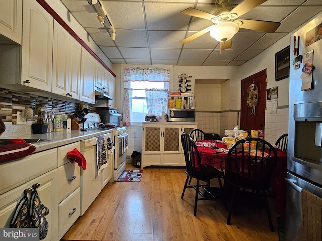 kitchen featuring a drop ceiling, light hardwood / wood-style flooring, stainless steel appliances, and tile walls