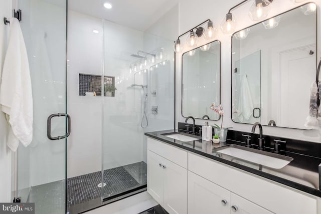 bathroom with a shower with shower door and vanity