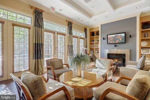 sitting room with built in shelves, coffered ceiling, beamed ceiling, ornamental molding, and hardwood / wood-style flooring