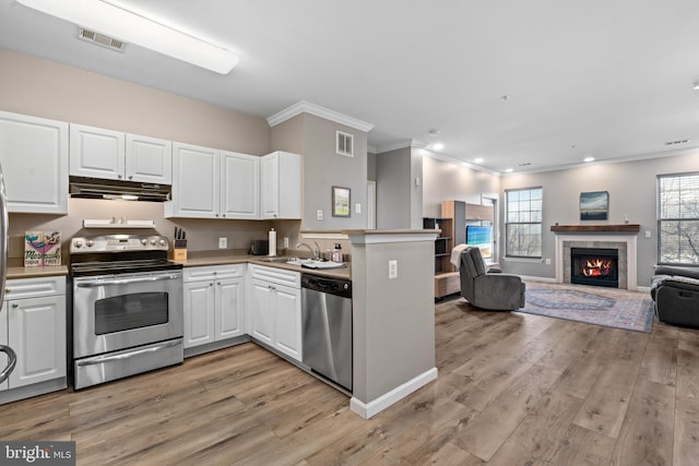 kitchen with appliances with stainless steel finishes, sink, white cabinets, and light hardwood / wood-style flooring