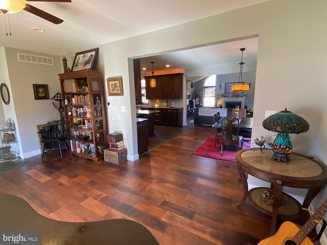 living room with ceiling fan and dark hardwood / wood-style flooring