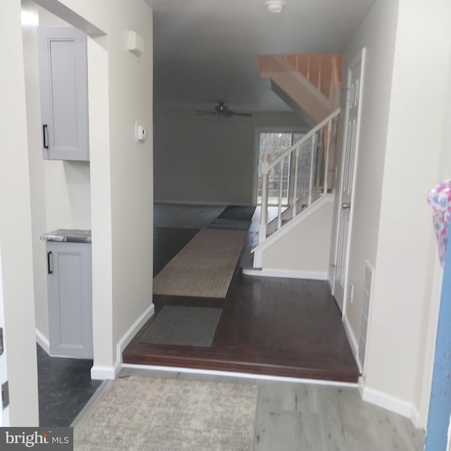 stairs with ceiling fan and hardwood / wood-style flooring