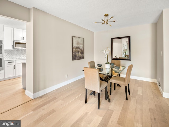 dining room with a textured ceiling and light wood-type flooring