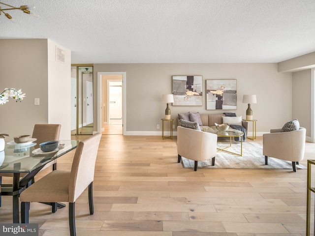 living room featuring a textured ceiling and light wood-type flooring